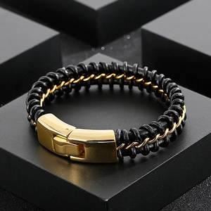 Detail of black braided leather and gold stainless steel chain link bracelet for men
