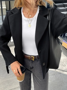 Casual street style outfit with elegant black blazer, white t-shirt and grey jeans