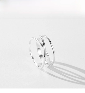 Macro shot of minimalist silver geometric rings with interlaced lines and artistic shadows