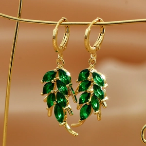 Close-up of golden leaf earrings with nine marquise-cut emerald green crystals