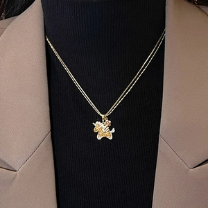 Elegant gold double-layered unicorn necklace with zircon crystals and red accents on model