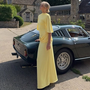 Close-up of yellow backless maxi dress with tiered draping and waist pleats detail