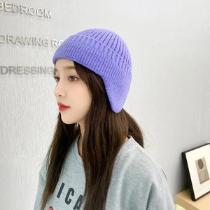 Detailed texture of purple cable knit earflap hat for winter wind protection