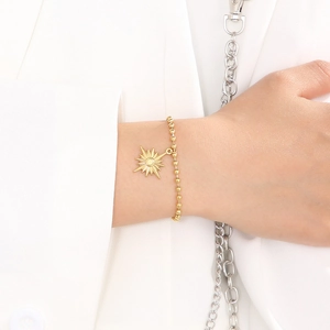 Détail d'un bracelet à billes plaqué or 18 carats avec un pendentif étoile minimaliste chic
