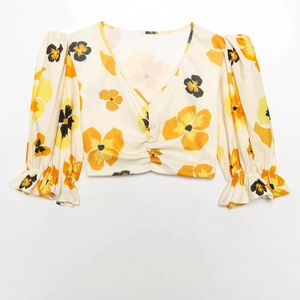 Floral puff sleeve V-neck crop top with yellow flower print on a cream ribbed fabric