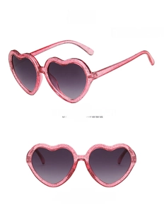 Detail of pink glitter heart sunglasses for kids with grey gradient lenses