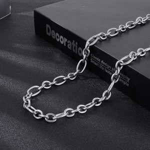 Close-up of thick stainless steel oval link chain necklace on black textured background