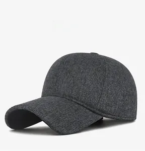 Dettaglio cappello invernale grigio da uomo con paraorecchie e logo SORT in metallo