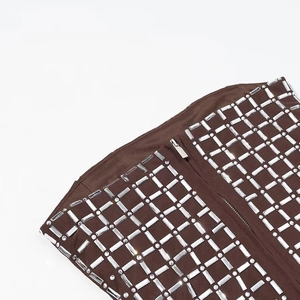Dettaglio del set corsetto marrone con strass rettangolari lucidi e chiusura a zip frontale