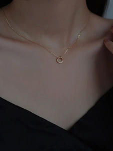 Close-up of a 14k gold plated S925 silver square necklace worn on a black silk V-neck