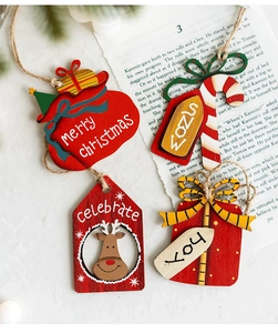 Set of four rustic wooden Christmas tree ornaments with festive greetings on a vintage page