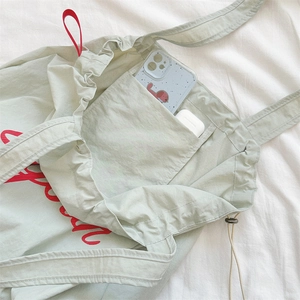 Close-up of the internal pocket and lining in a light green nylon drawstring tote bag