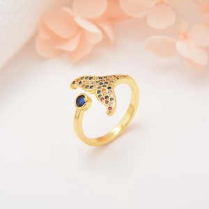 Detail of whale tail ring with colorful crystals and a deep blue gemstone accent