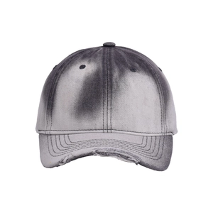 Detail shot of distressed cotton baseball cap featuring gradient dye and frayed brim edge