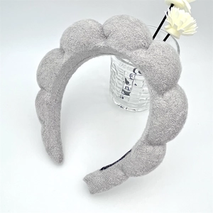Close-up of thick grey cloud headband with soft knitted texture and plush padded design