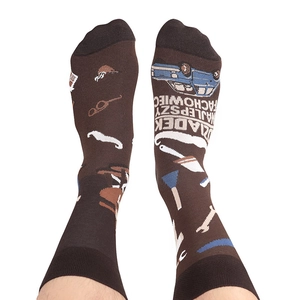 Detailed view of asymmetrical crew socks with car and tool patterns on brown cotton fabric