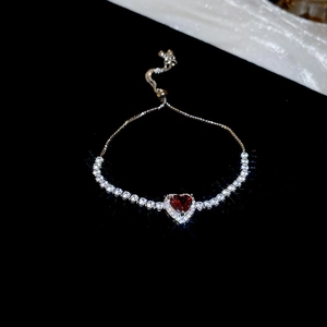 Macro detail of adjustable flower bracelet with a red heart gem and cubic zirconia