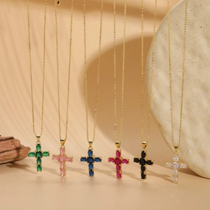 Macro detail of six colorful zircon cross necklaces with gold chain in a minimal setting