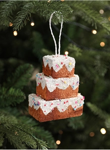 Detailed view of brown glittered cake-shaped Christmas tree ornament with white snow icing