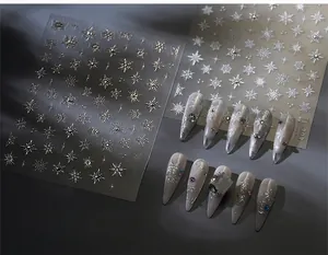 Detail of silver snowflake nail decals showing metallic texture and crystal accents