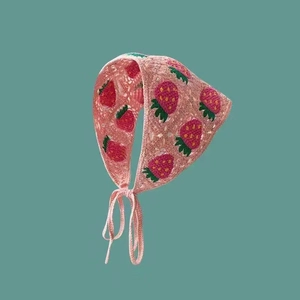 Detailed macro view of pink strawberry pattern crochet knit headscarf with soft ties