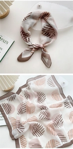 Close-up of abstract geometric print silk scarf with fine fabric texture and hand-sewn edges
