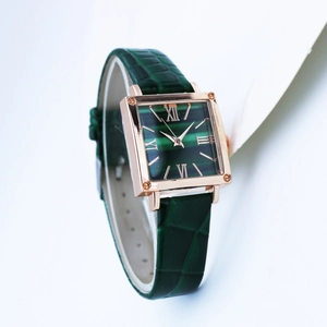 Detail of square rose gold watch with green malachite dial and Roman numerals