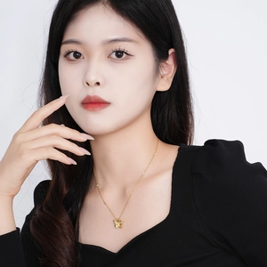Elegant gold butterfly pendant necklace with colorful zircons worn by a model