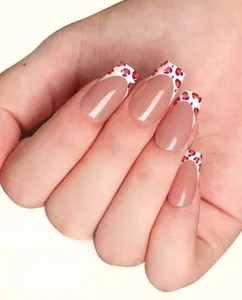 Macro detail of nude pink press-on nails with white tips and red leopard pattern