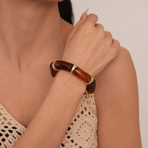 Close-up of tortoise shell resin bamboo bracelet with polished gold metal spacers