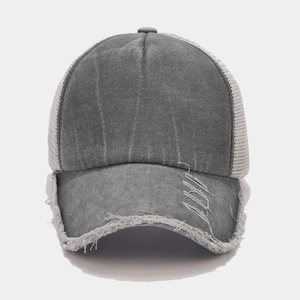 Dettaglio del cappello trucker grigio scuro con denim consumato e trama a rete