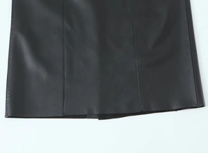 Close-up of black faux leather fabric texture and premium stitching details on the hem