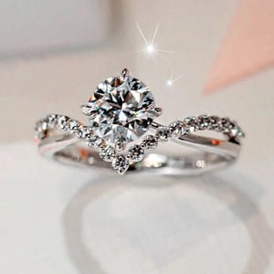 Macro shot of crown V-shaped engagement ring with round center diamond and twisted band