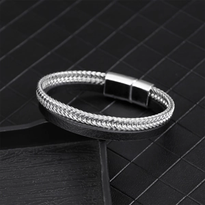 Men's leather bracelet with silver chain and magnetic clasp on a textured surface