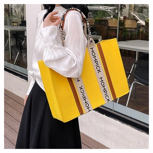 Detailed view of yellow felt tote bag with MOMPICK logo straps on shoulder