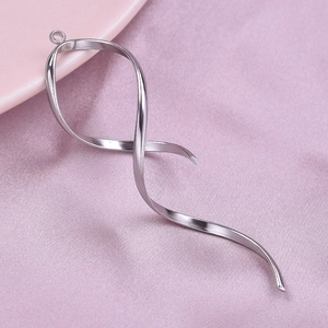Close-up of a silver 304 stainless steel twisted ribbon pendant on pink textured fabric