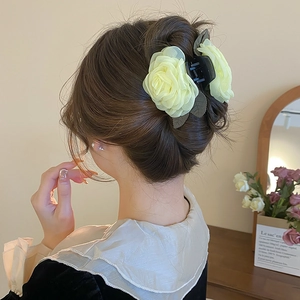 Detail einer gelben Organza-Rose und Perlen-Haarklammer für einen Dutt-Haarschnitt