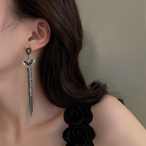 Silver tassels heart earrings with rhinestones shown on model in a side profile view