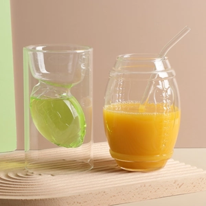 Creative double-walled rugby glass cup and ribbed highball glass with straw on a tray