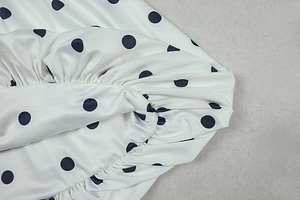 Detail of the elastic pleated hem on white and black polka dot A-line dress fabric