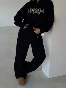Women's black two-piece lounge set with embroidered half-zip sweatshirt and wide-leg pants