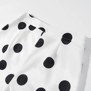 Détail de la taille avec pois noirs sur tissu blanc et finitions de couture précises