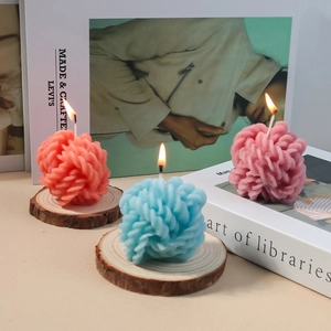 Tres velas aromáticas de colores con textura de punto en espiral sobre bases de madera