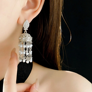 Detail showing vintage silver tassel earrings with pearls and rhinestones on a model