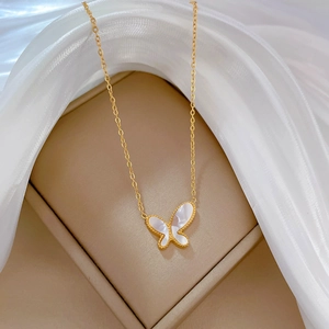 Detail of gold titanium steel necklace featuring a white mother-of-pearl butterfly pendant