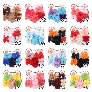 Detailed grid of 16 hair accessory sets with bows, flowers, and plush balls on bear cards