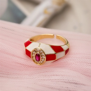 Macro detail of 18K gold plated open ring with red enamel and oval zircon setting