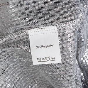 Vue détaillée de l'étiquette 100% polyester et des sequins sur la chemise chic