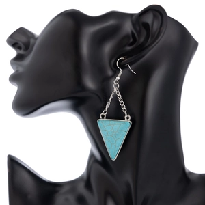 Close-up of blue turquoise triangle earrings with silver hooks on a model silhouette