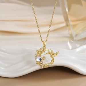 Detailed shot of hummingbird and flower pendant with round opal-like stone and zircons